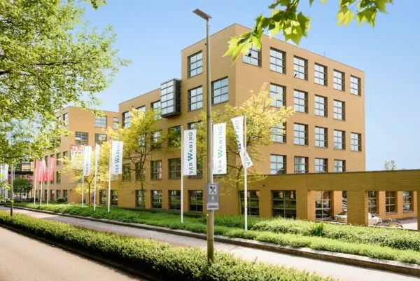 Kantoorverzamelgebouw aan de Rivium 2e Straat in Capelle aan den IJssel met vlaggen van Van Waning voor de gevel.